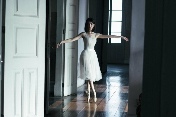 A beautiful ballerina in the middle of an empty room