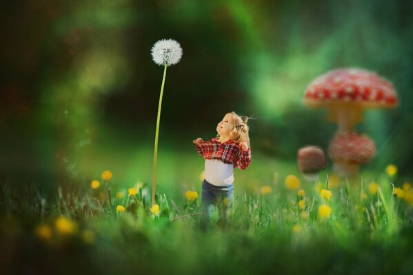 Маленькая девочка и огромный одуванчик на поляне