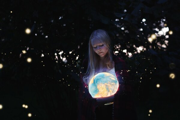 Chica rubia con un globo luminoso en sus manos