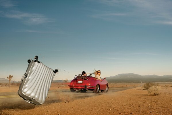 La valise est tombé de la voiture rouge, au milieu du désert