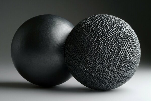 Deux boules noires sur une surface blanche