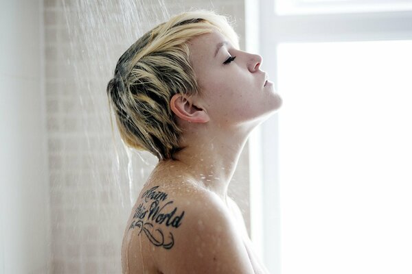 Young girl with a tattoo in the shower