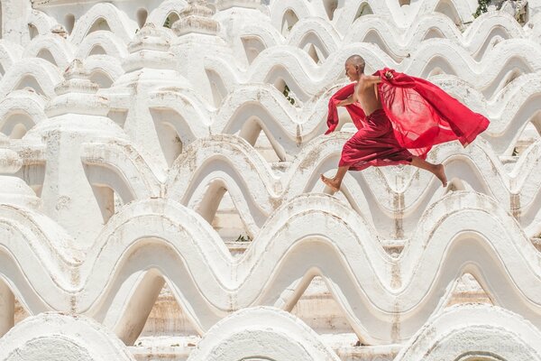 A boy running in a red skirt