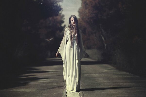 A girl in a white dress in the middle of the road