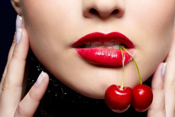 A girl s face with red lipstick on her lips and a cherry