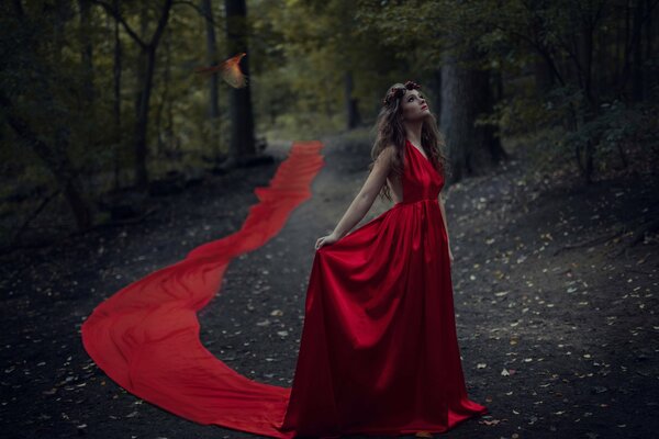 Belle fille en rouge dans une robe de plancher