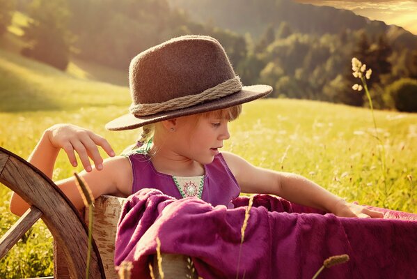 A girl in a hat on a sunny meadow