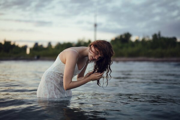 A girl with freckles and wet hair in the water