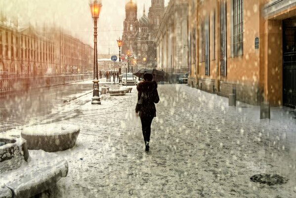 A girl with an umbrella in the rain on St. Petersburg street