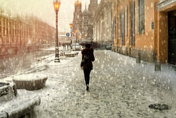 Jeune fille avec un parapluie sous la pluie dans la rue peter
