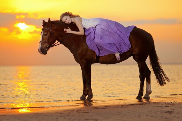 A girl riding a horse by the sea