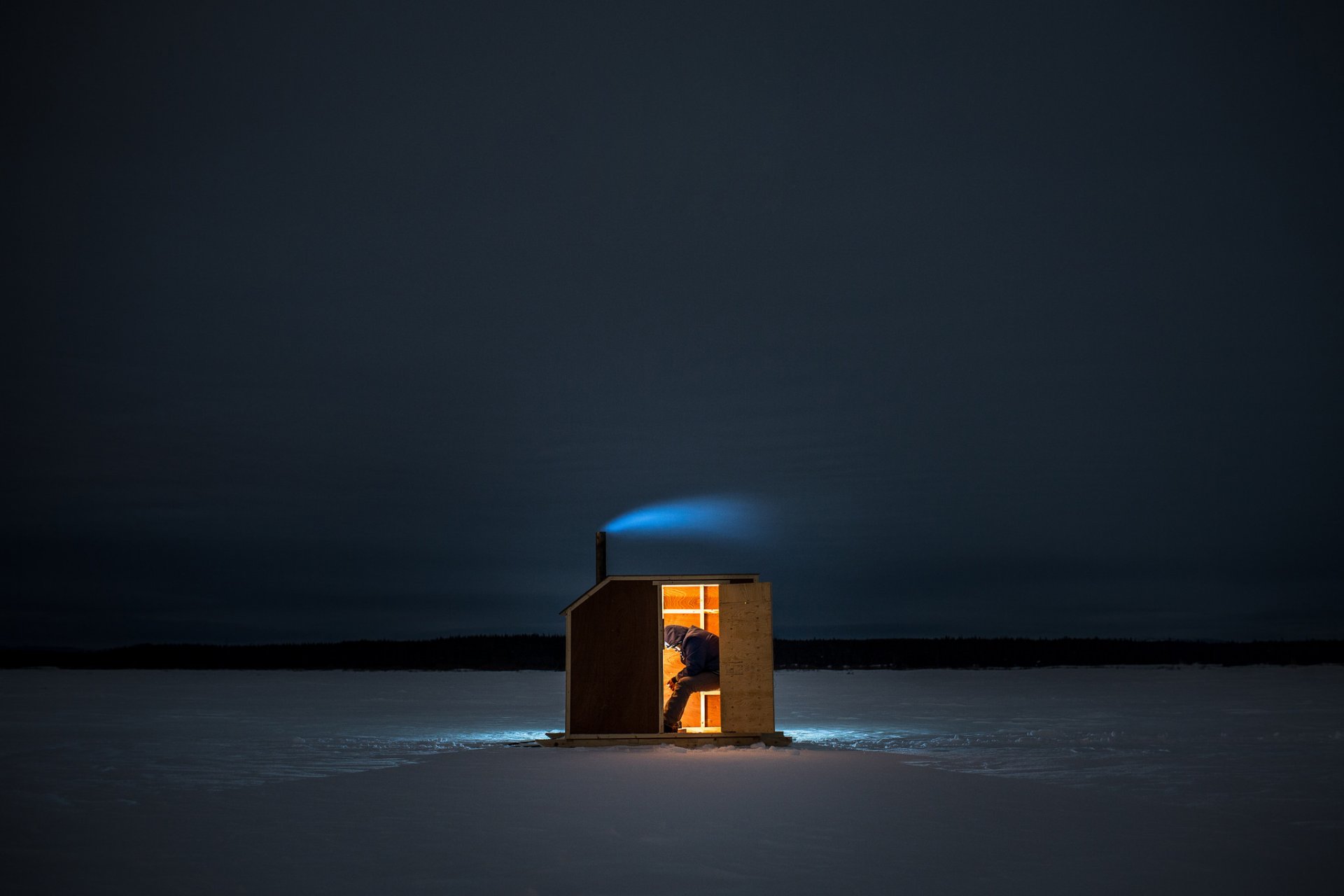 l homme de la pêche de la fumée glace lac lumière l horizon les montagnes le ciel la nuit