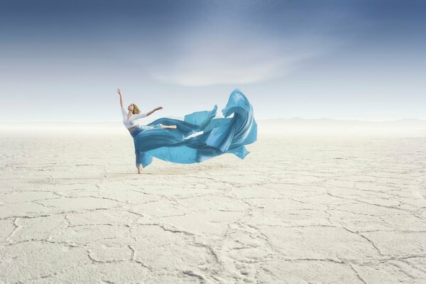 Danseuse dans le désert avec le bleu de longue