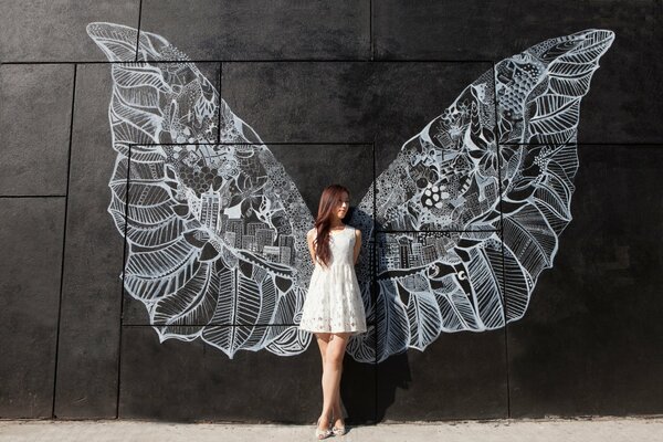 Chica en vestido blanco con alas