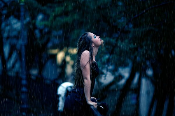 Chica se moja bajo la lluvia fría