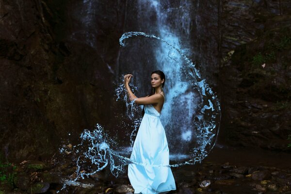 Chica y cascada. Hermosa chica en la naturaleza