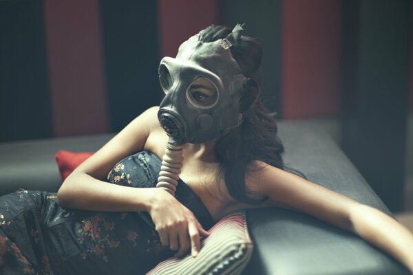 Model Karen David on the couch in a gas mask