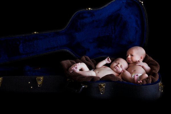 Mignons bambins dans un étui de violon sous