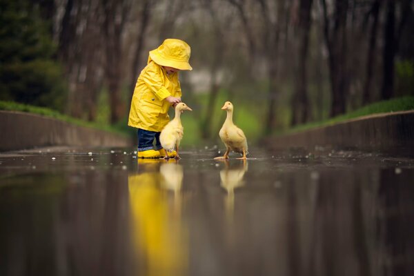 Bambino in un mantello giallo con paperi