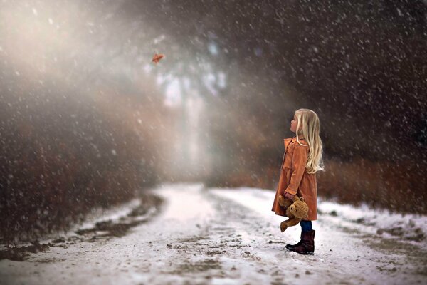 Winter forest. A girl with a bear cub