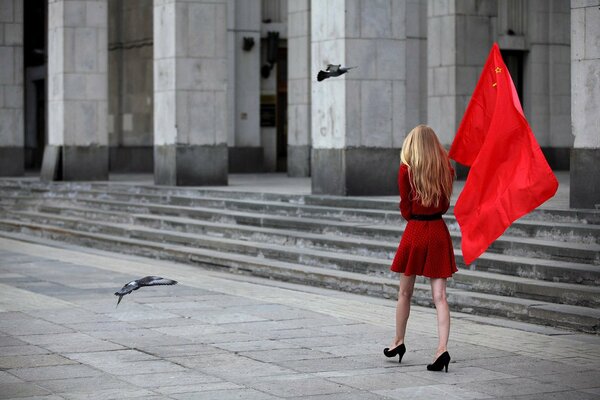 Belle fille avec drapeau et pigeons