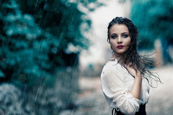 Beautiful girl standing in the rain