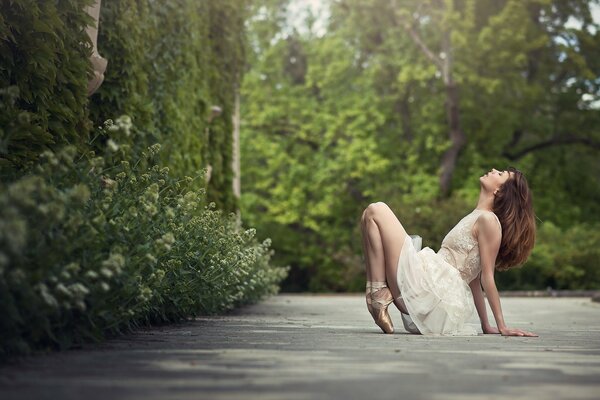 Bella ragazza in scarpe da punta nella foresta verde