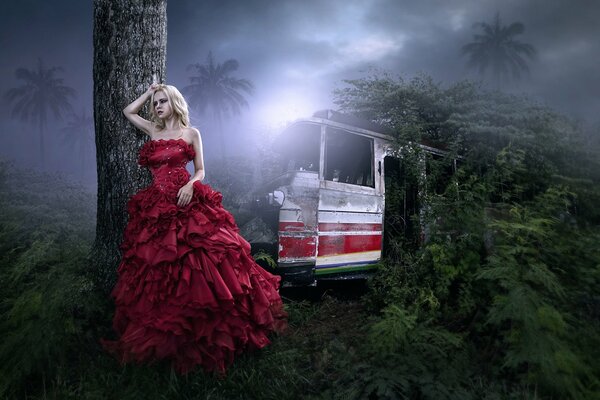 Chica en vestido rojo en la selva oscura