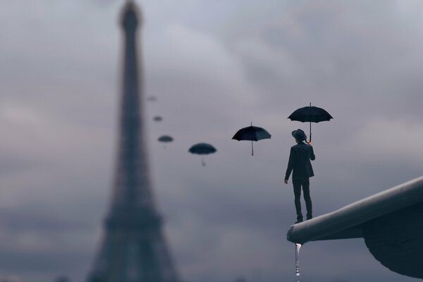 A man on the edge with umbrellas up to the tower