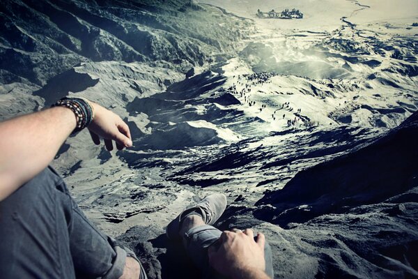 David olkarny fotógrafo se sienta en una roca alta y toma fotos de la vista desde arriba