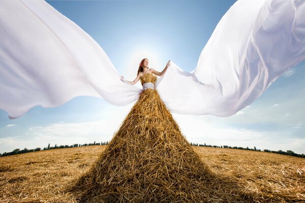 Foto creativa di una ragazza su un mucchio di fieno