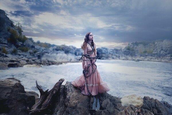 A girl tied up on the shore of a pond