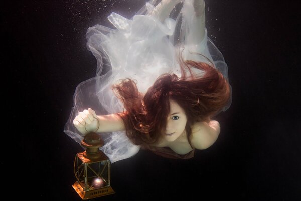 A girl lights a lamp under water