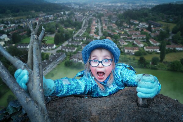 The girl holds on to the branch and screams