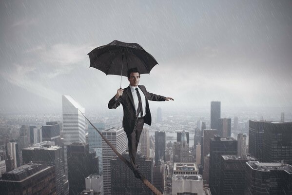 Mężczyzna z parasolem idzie po linie w deszczu