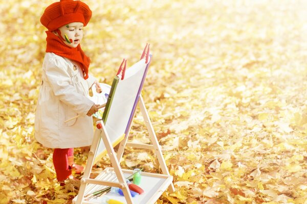 A little artist. Autumn leaf fall