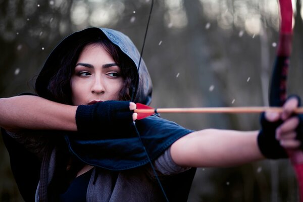 The girl pulls the bowstring
