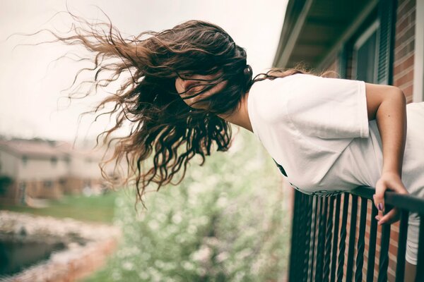 Das Mädchen auf dem Balkon schaut ihr Taxi an, um zu fahren, wohin toBal geht