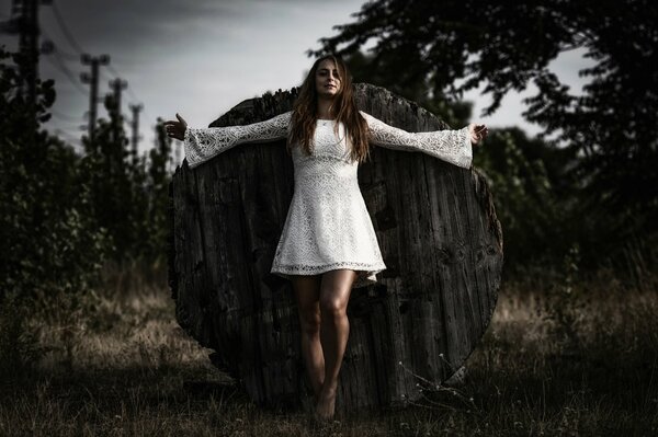 Bella ragazza in abito bianco in posa nella foresta