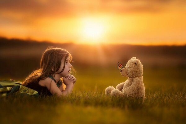 Baby and bear at a bright sunset