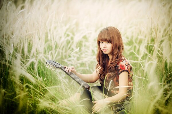 Asiatique sur le terrain avec une guitare