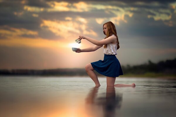 La jeune fille au coucher du soleil dans l eau