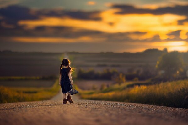 A girl with a book on a string is walking along the road