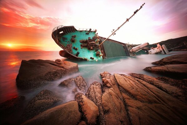 A ship after a shipwreck, thrown out of the sea on the rocks