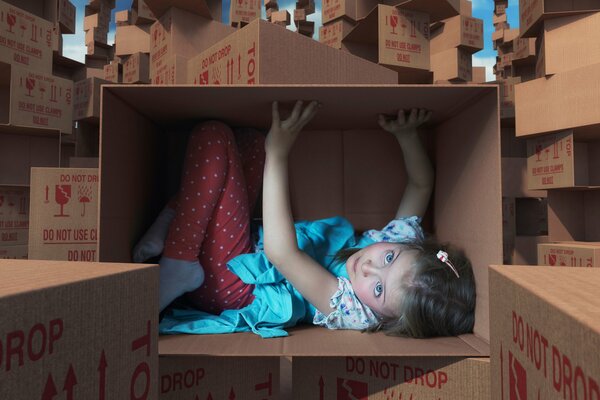 Petite fille dans une boîte en carton