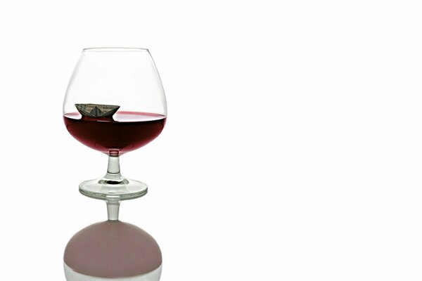 A small ship in a glass of red wine