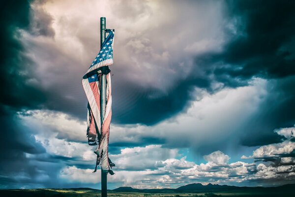 The flag of America on the background of a vague sky