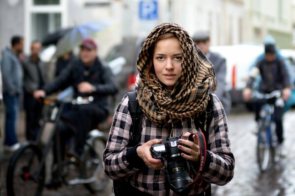 Młody fotograf na ulicy w deszczu