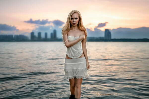 Beautiful girl in the water on the background of the city