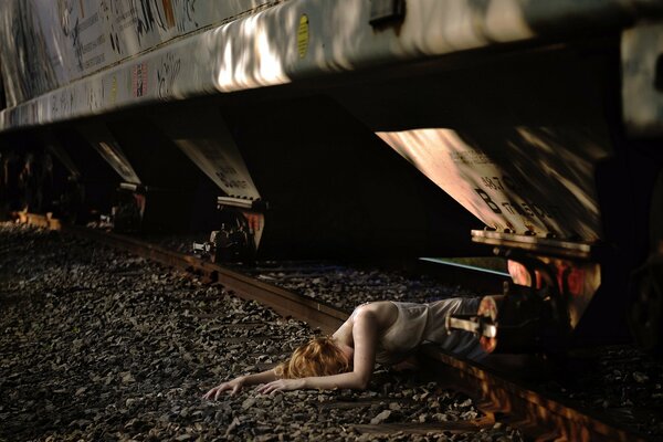 Lying girl on the tracks under the train